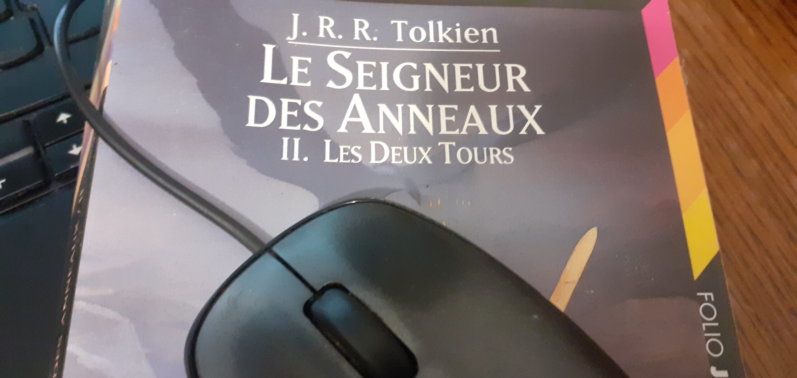 Une souris d'ordinateur posée sur le livre "le Seigneur des anneaux"