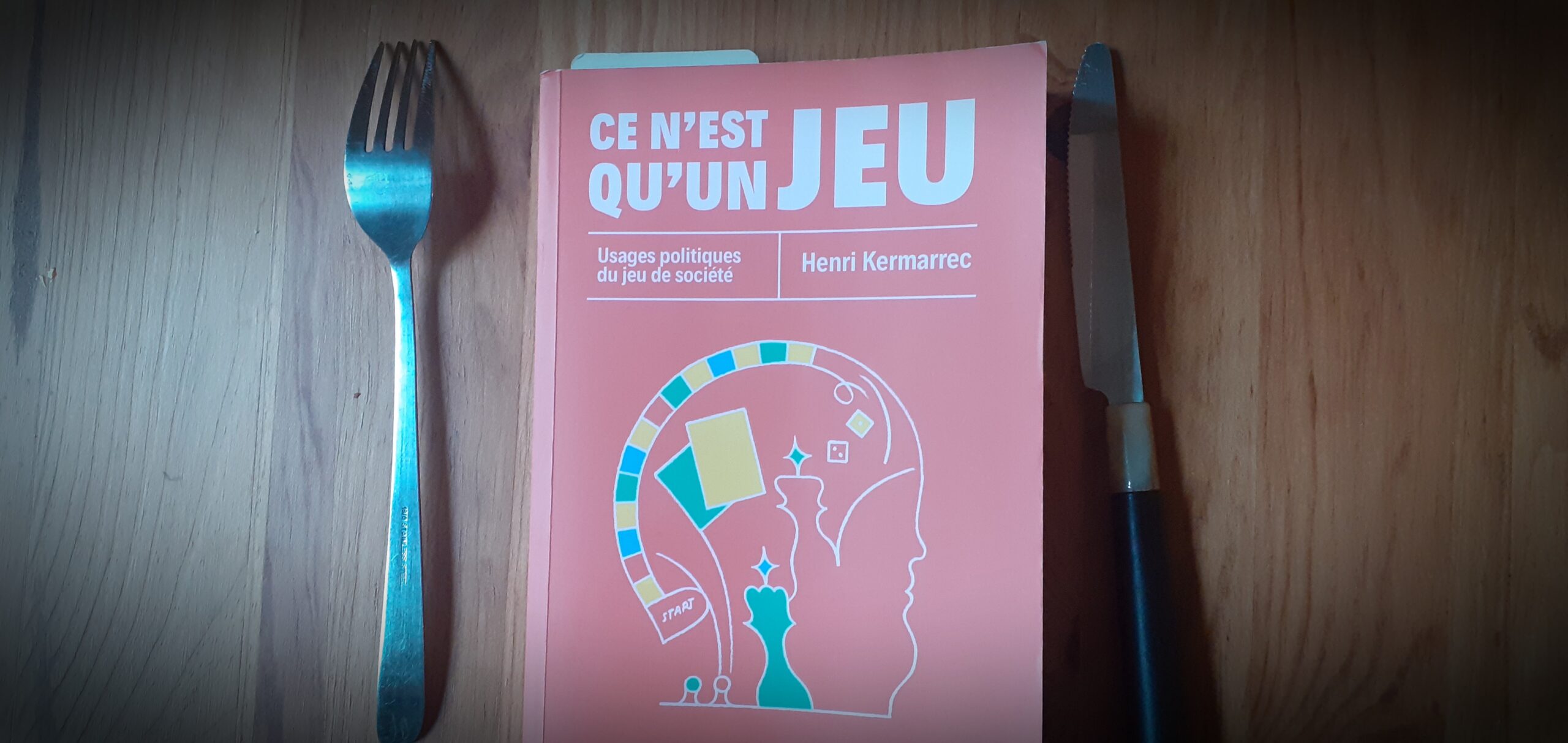 Le livre "Ce n'est qu'un Jeu" posé entre un couteau et une fourchette